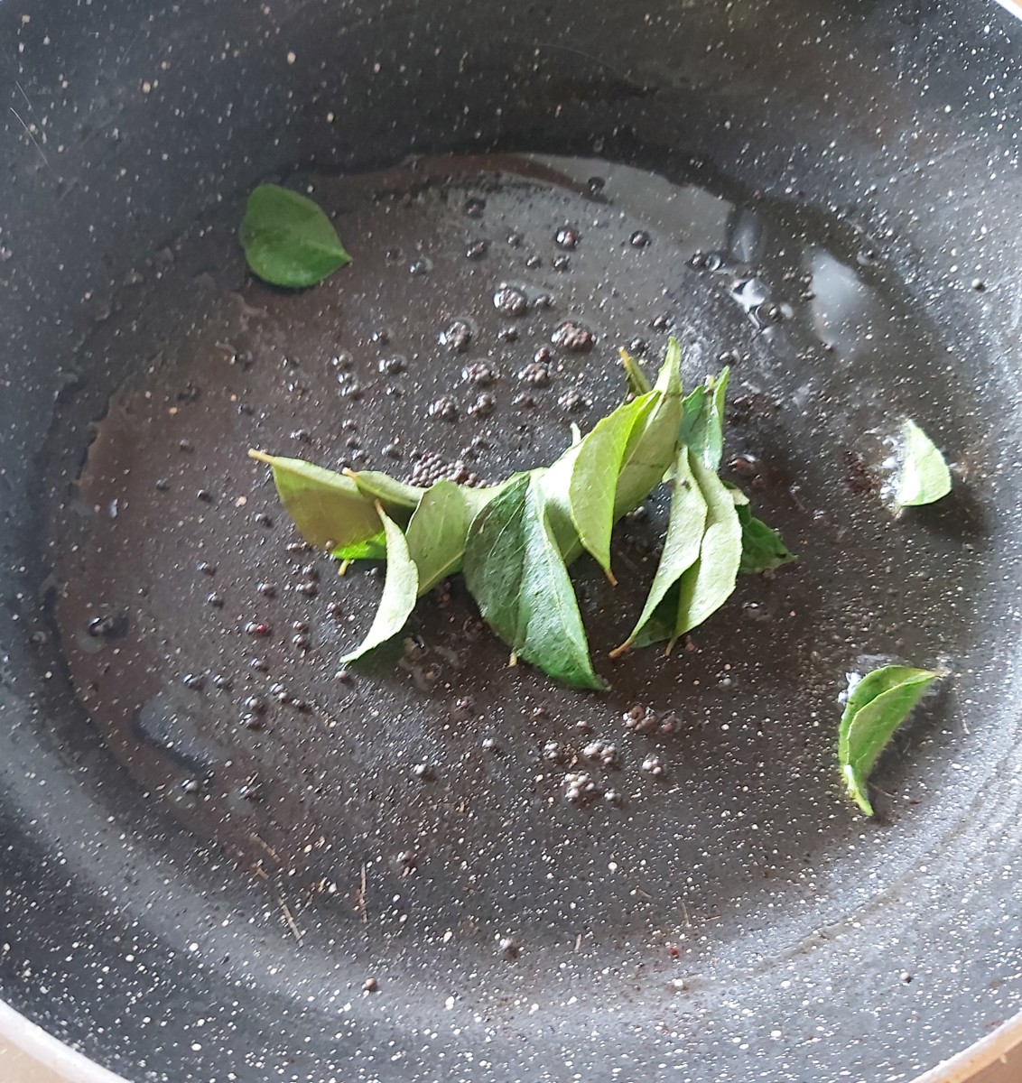 In a pan, heat oil, splutter the mustard seeds, and fry some fresh curry leaves.