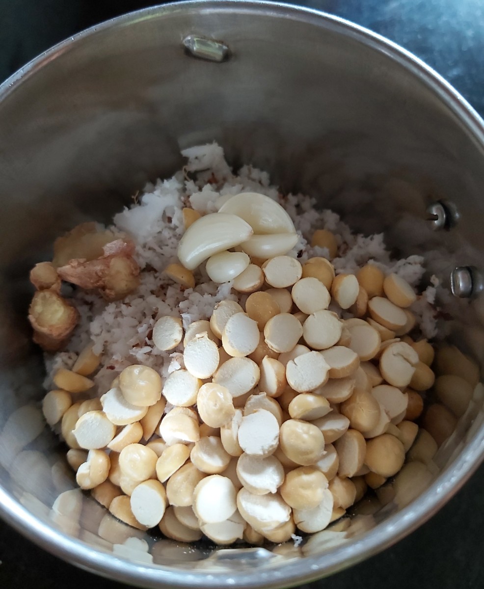 Transfer the grated coconut to a mixer jar. Add the fried gram, ginger, and garlic.
