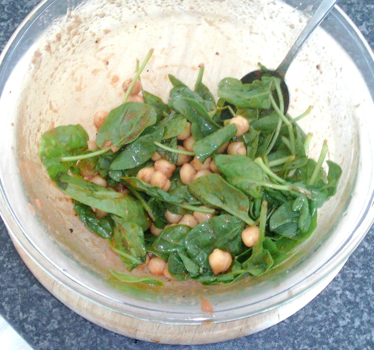 Spinach is stirred in to chickpeas in tomato sauce