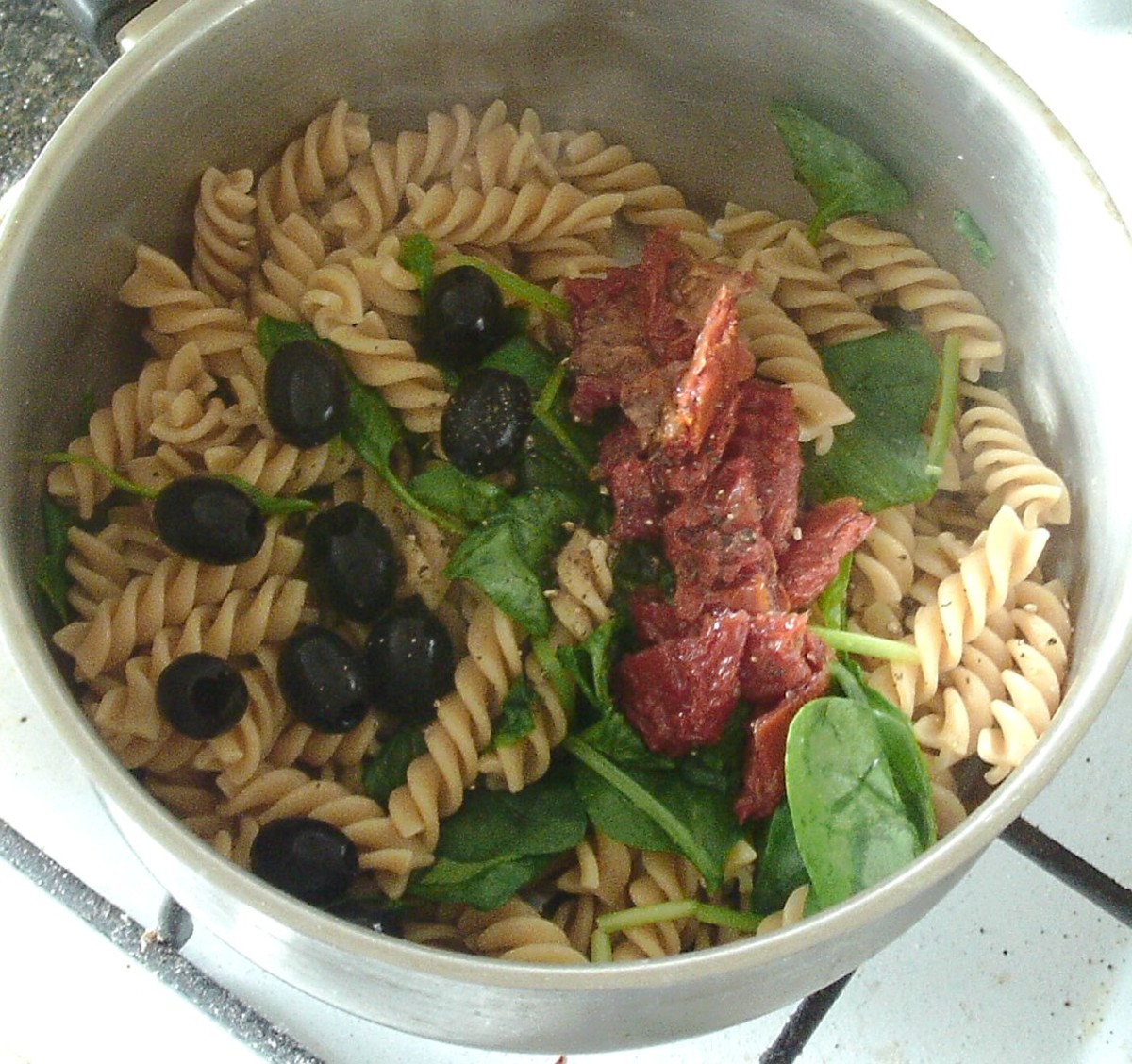 Sun-dried tomatoes and black olives are added to the pasta