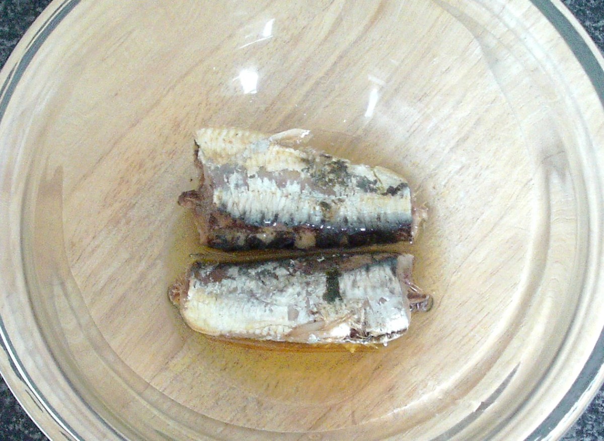 Canned sardines in olive oil are added to a large mixing bowl