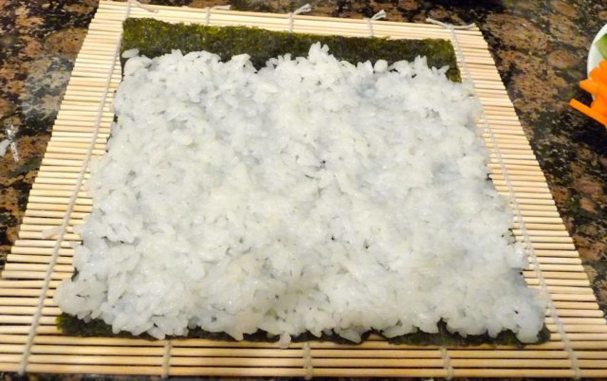 Press down the rice evenly, making sure not to tear the nori. Leave a 1 inch gap with no rice at the top.