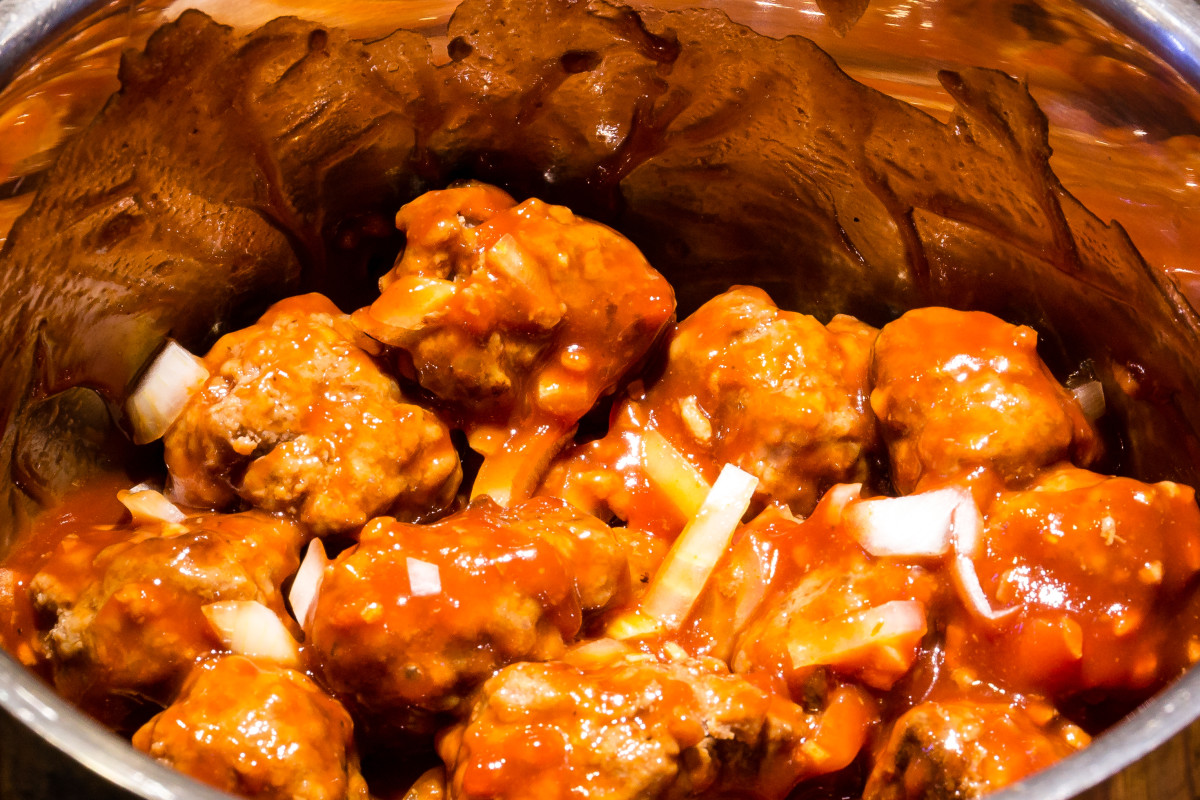 Meatballs simmering in garlicky smoked ketchup sauce