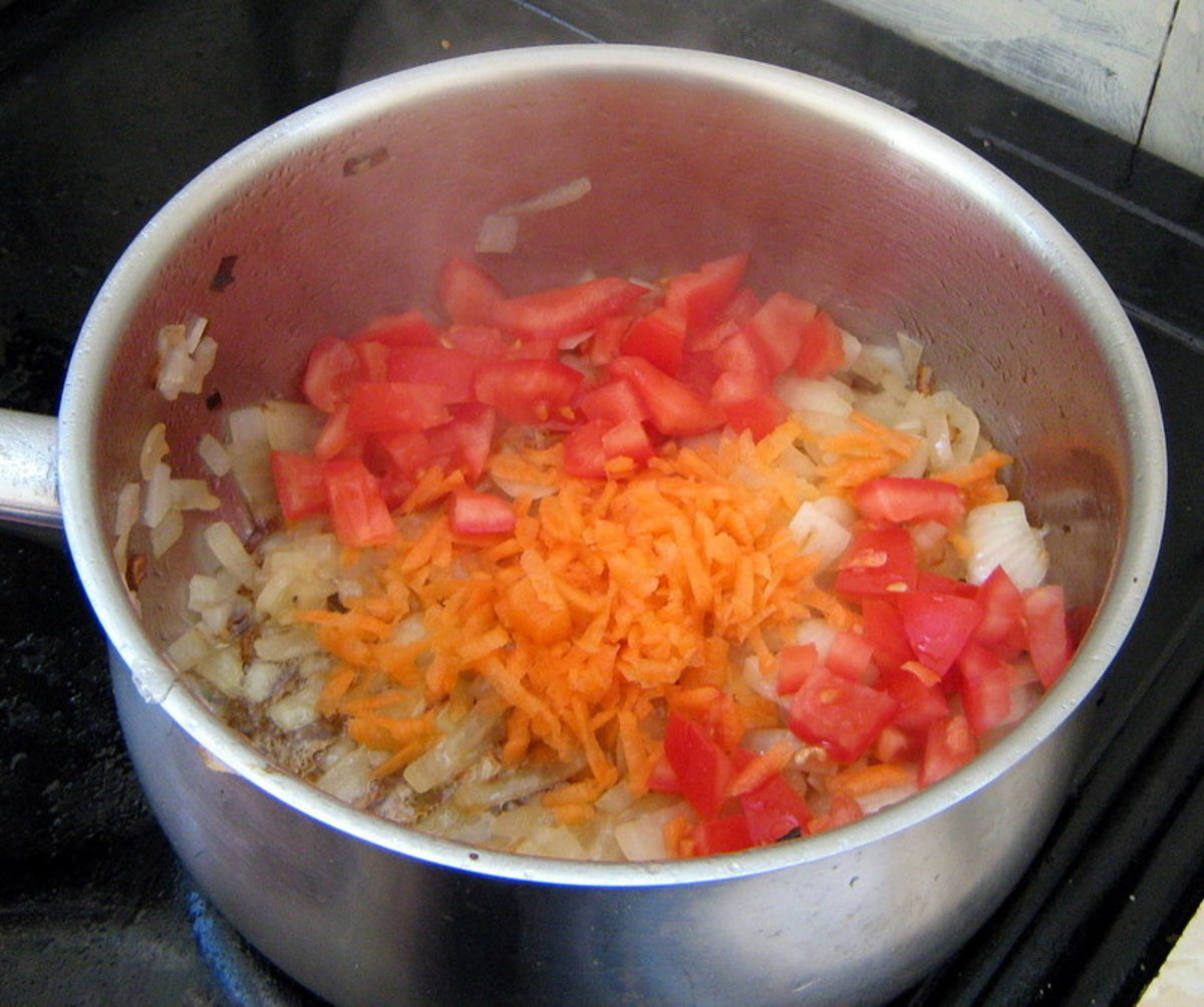 Add the grated carrot and tomatoes to the pot.