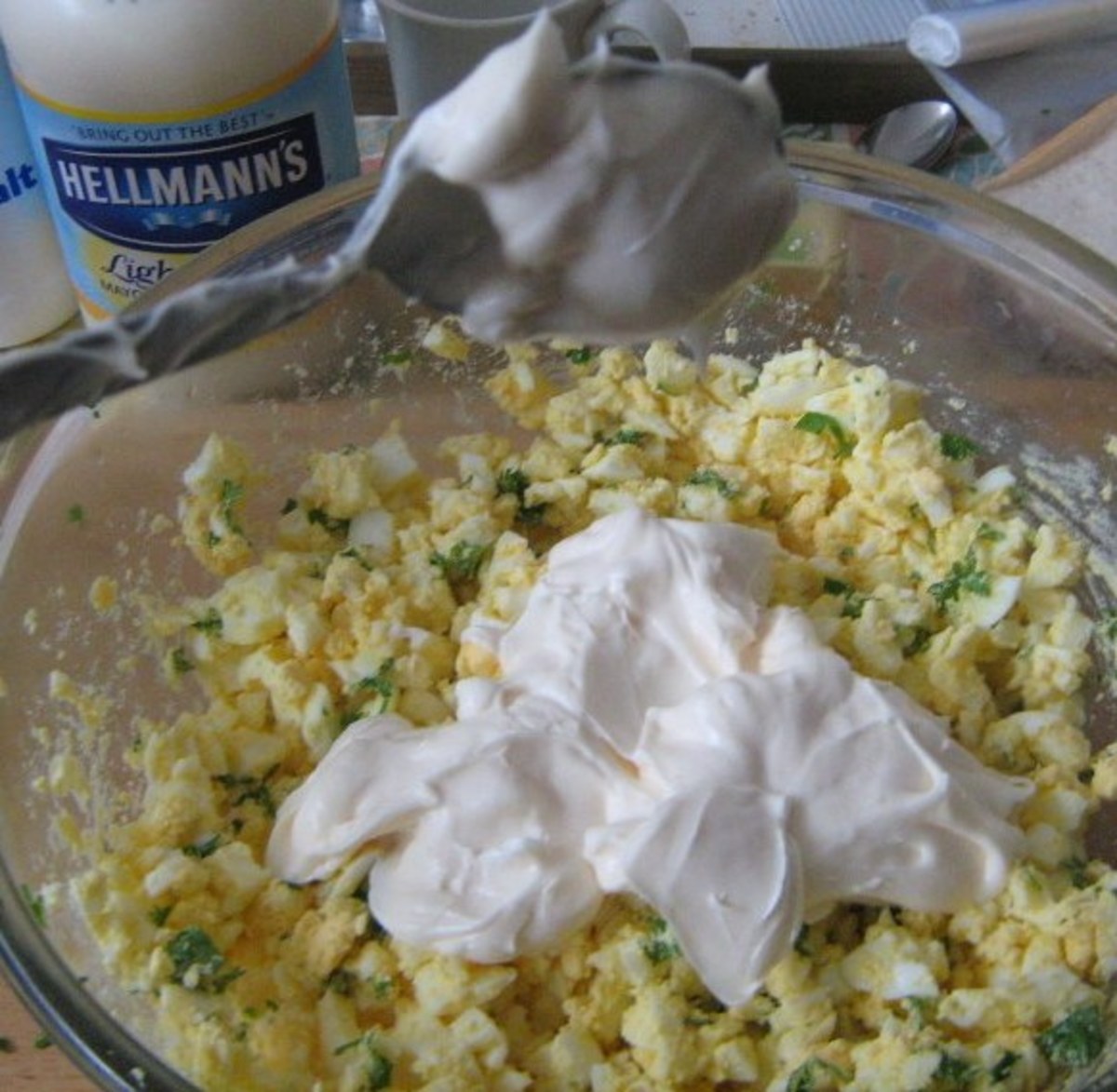 Take a few large spoons of mayonnaise and mix it with the boiled eggs.