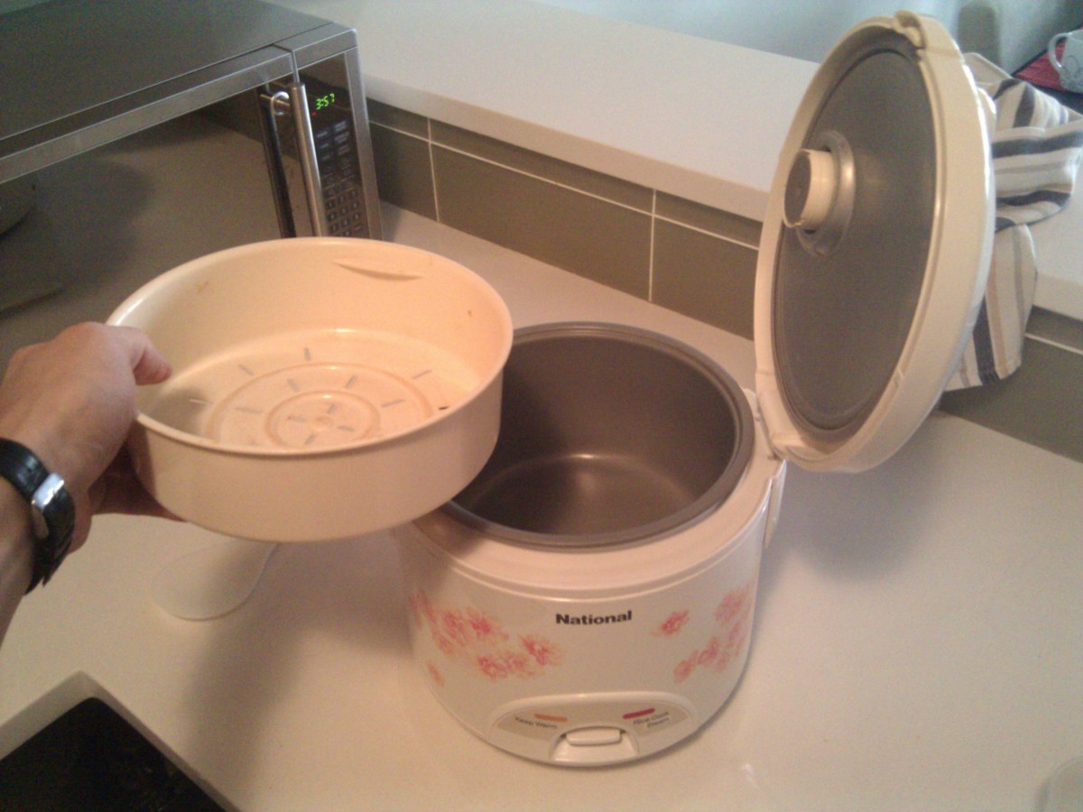 The steamer compartment is the white, plastic thingy to the left of the rice cooker.