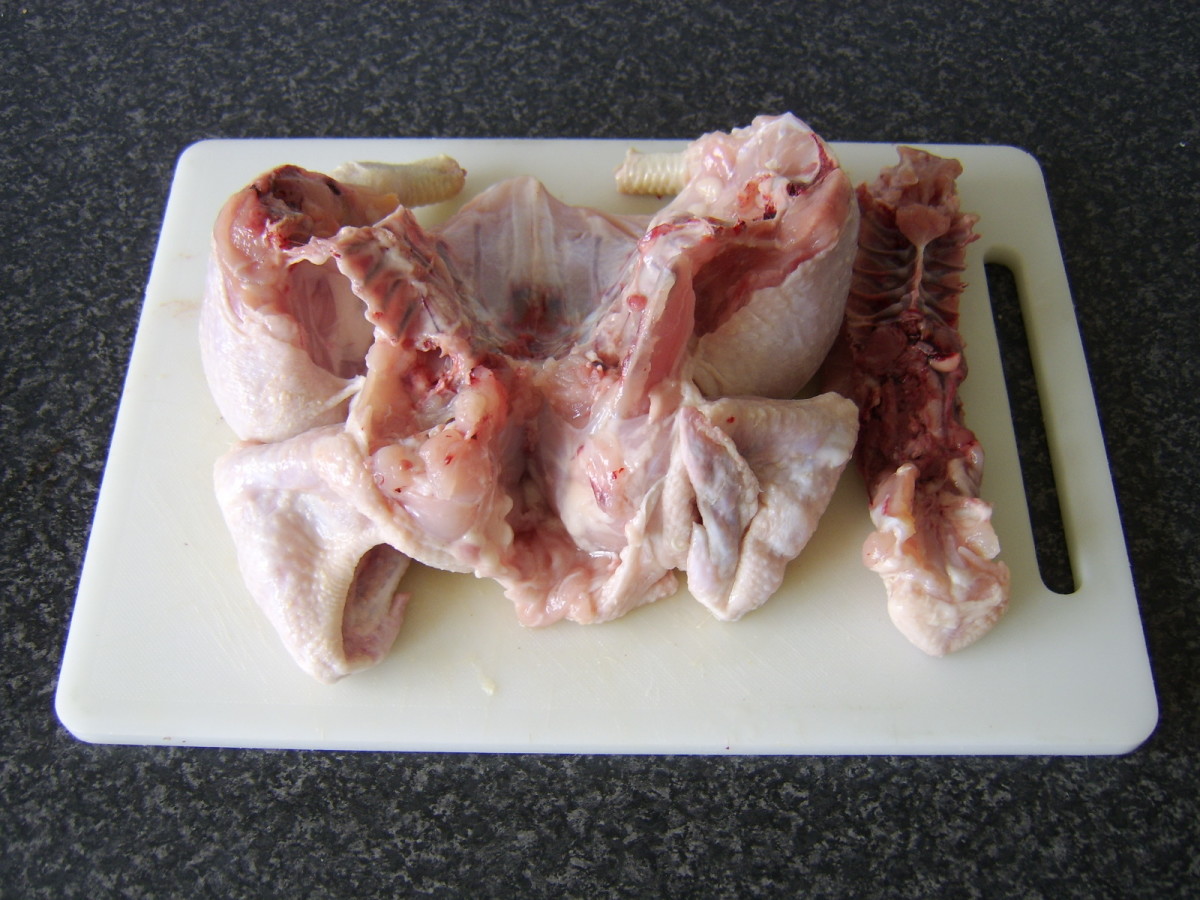 The backbone is carefully cut out of the whole chicken