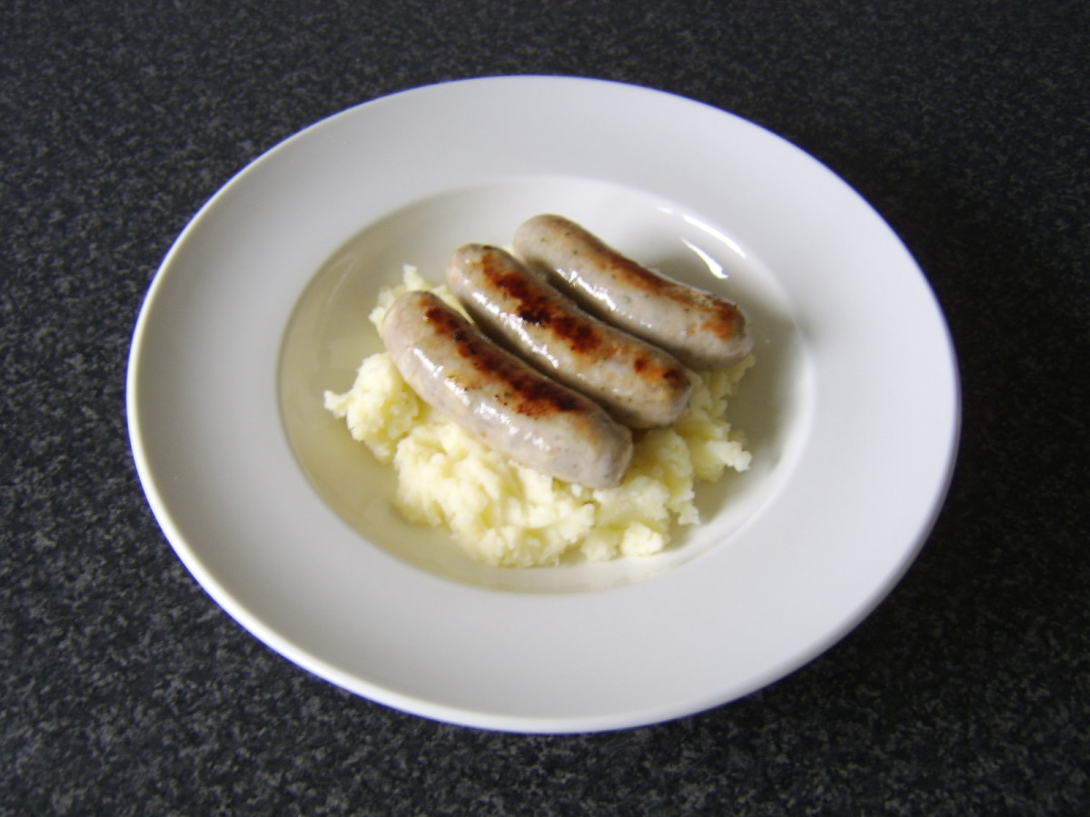 The pork and leek bangers are placed on top of the mash