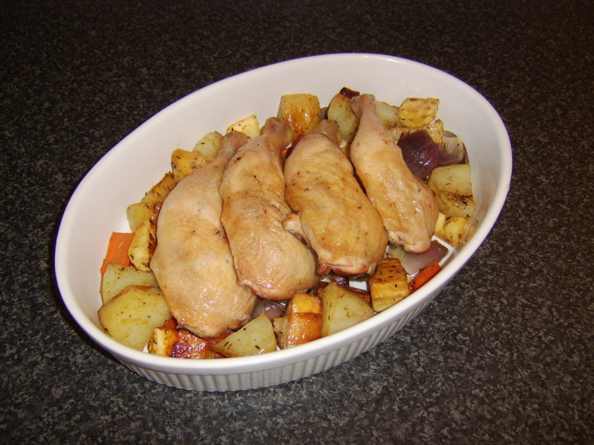 The vegetables are laid in a serving dish with the chicken legs on top