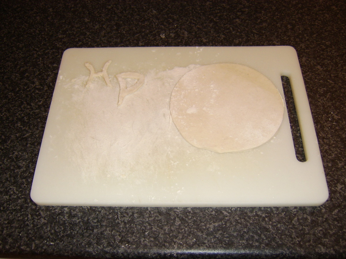A disc and letters are cut from rolled puff pastry