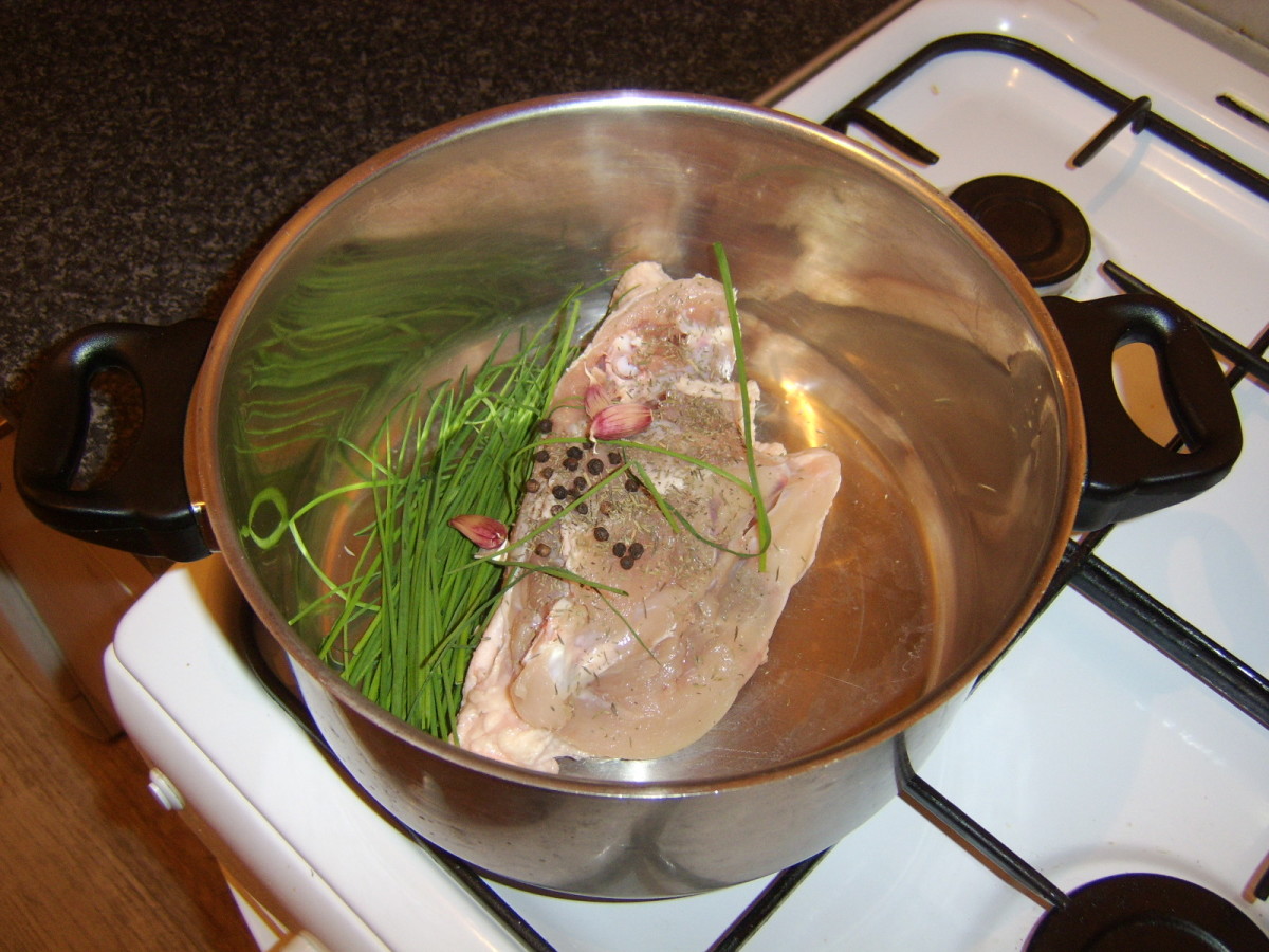 Improvised ingredients for vegetable free chicken broth are added to a large stock pot