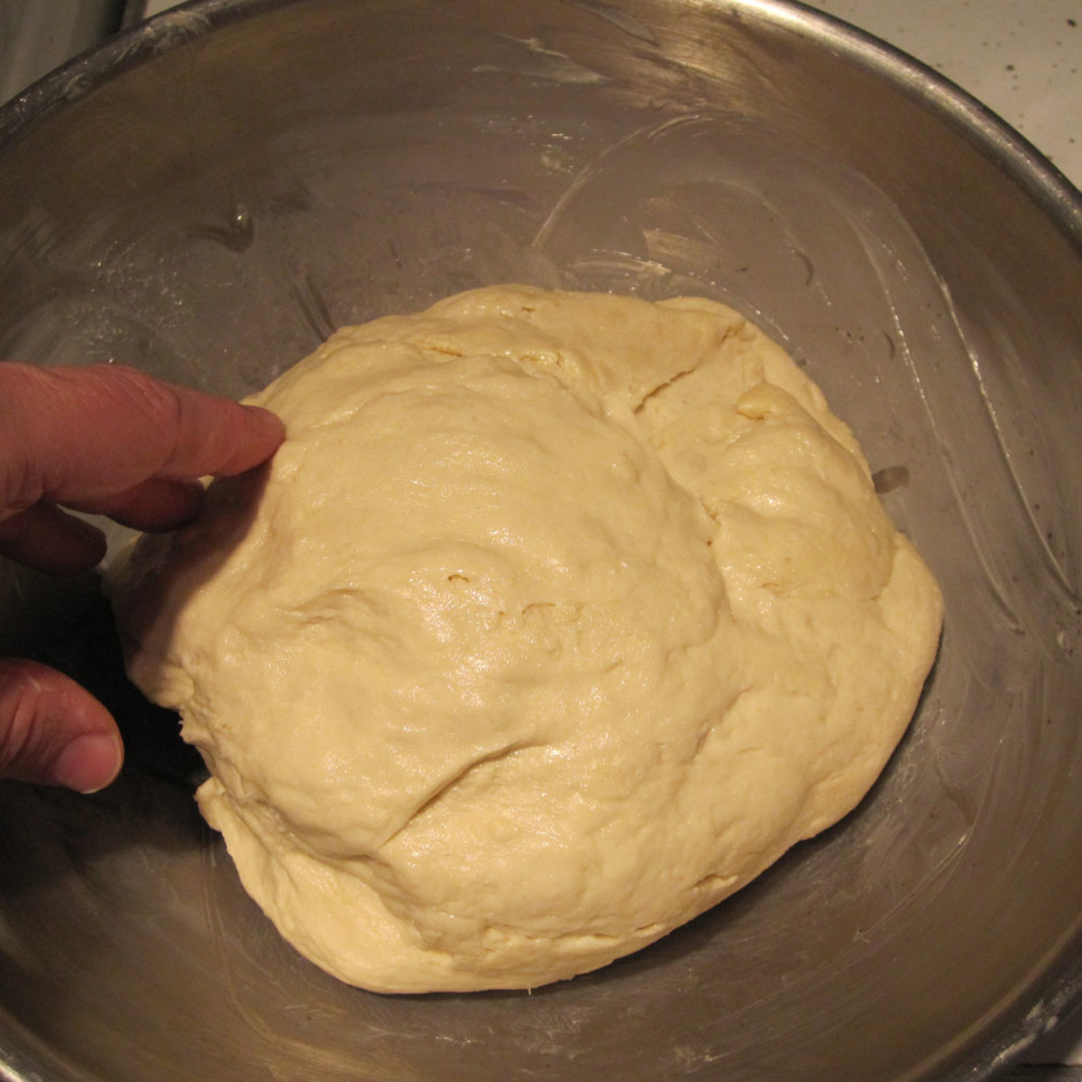 The completed dough is turned into a greased bowl for rising.