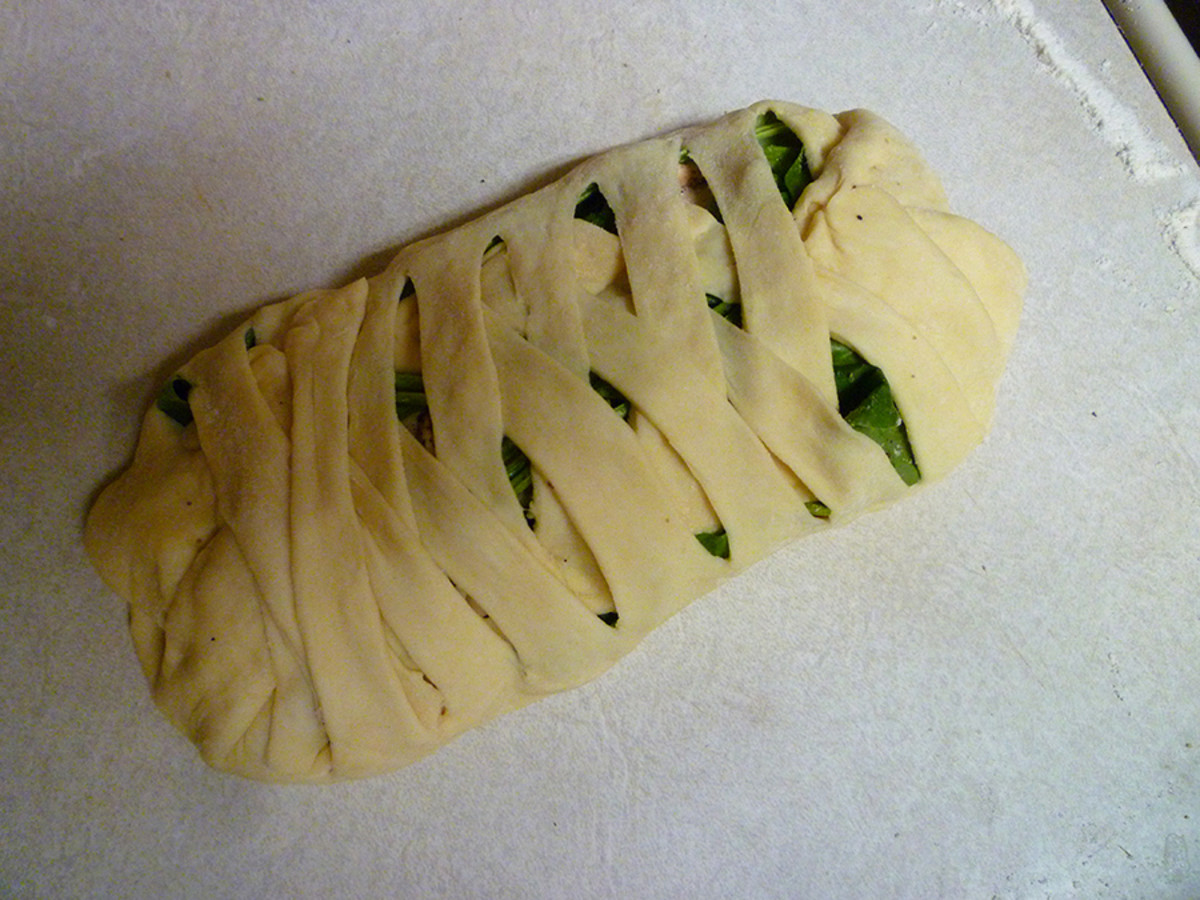 Slice edges of dough into one-inch strips and fold across the fillings in a criss-cross pattern.  