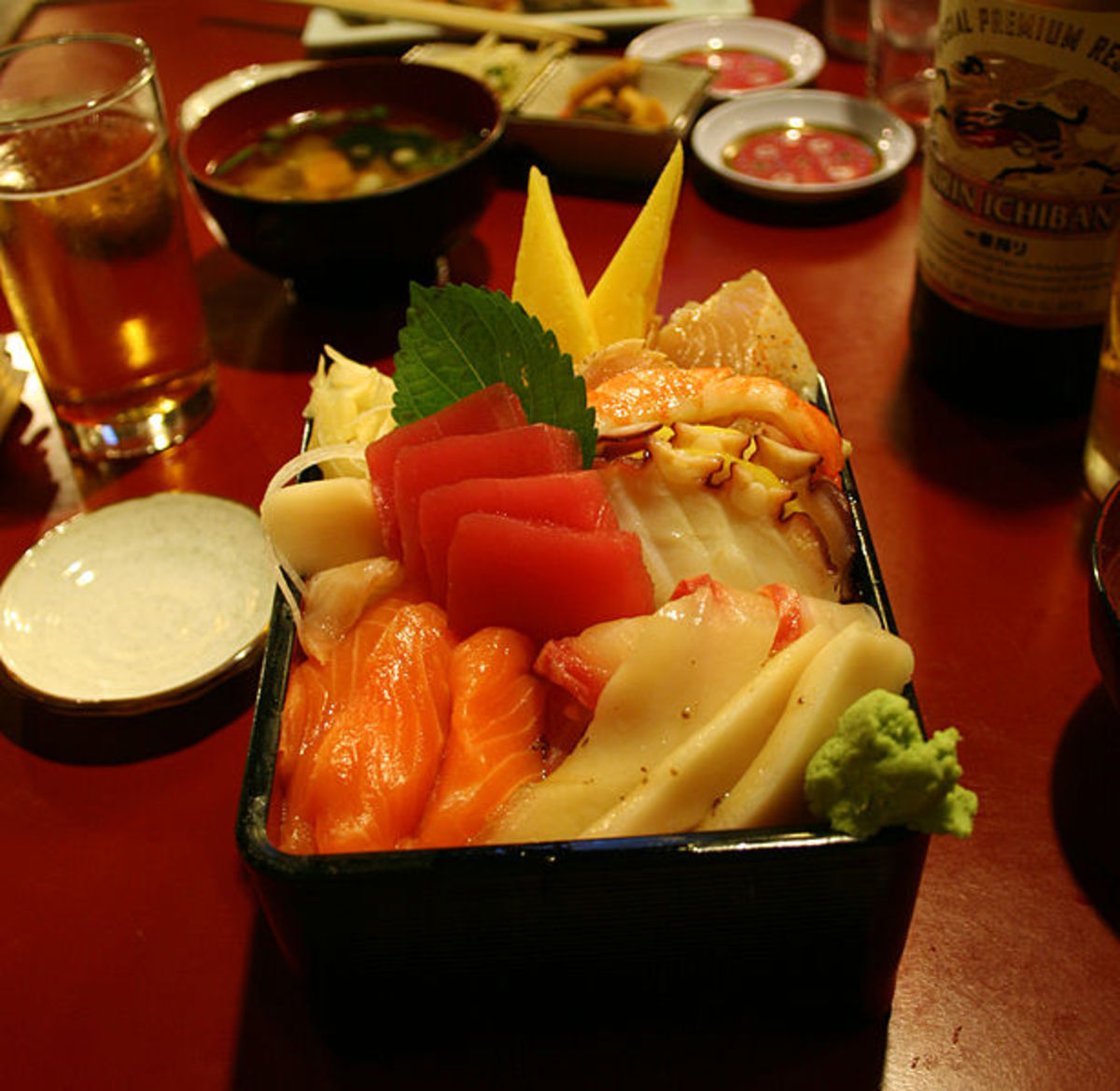 A Sashimi Bowl that has Rice covering the bottom.