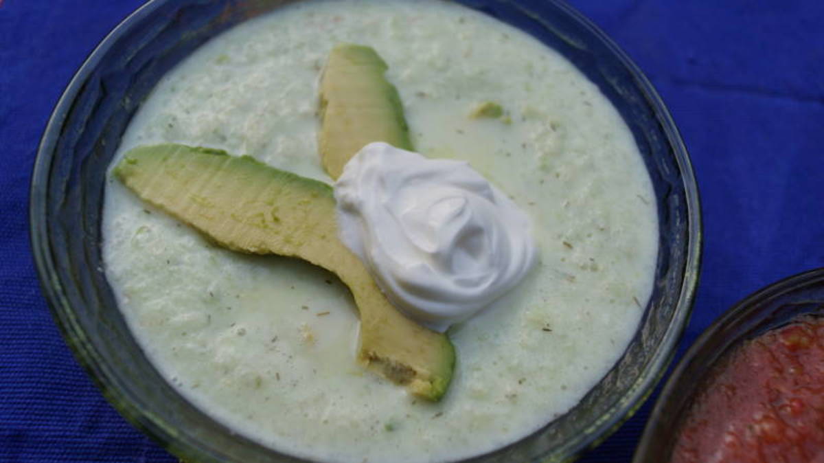 Cucumber yogurt soup garnished with avocado and sour cream.