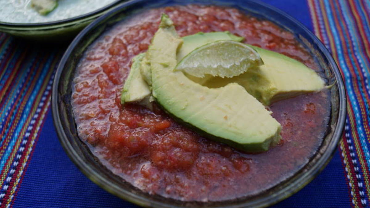 Gazpacho soup garnished with avocado and lime