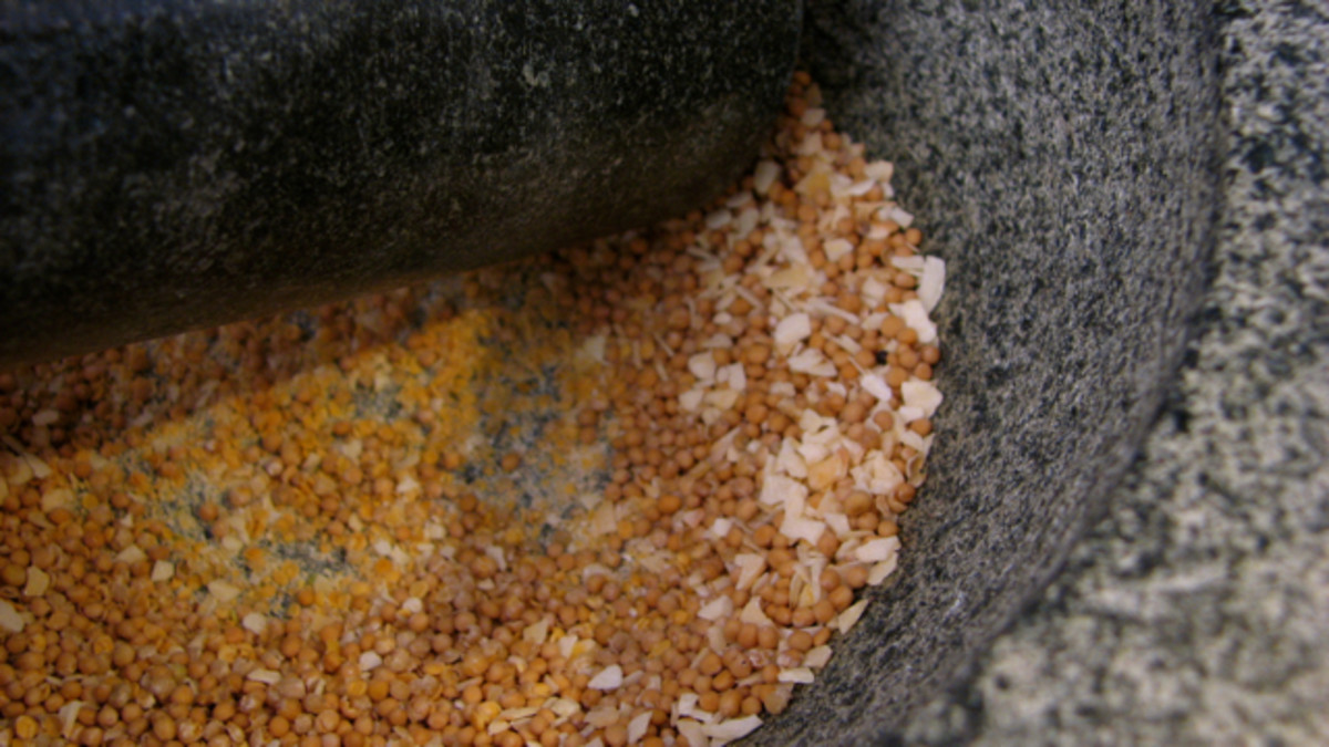 Grinding toasted spices and salt in a mortar and pestle.
