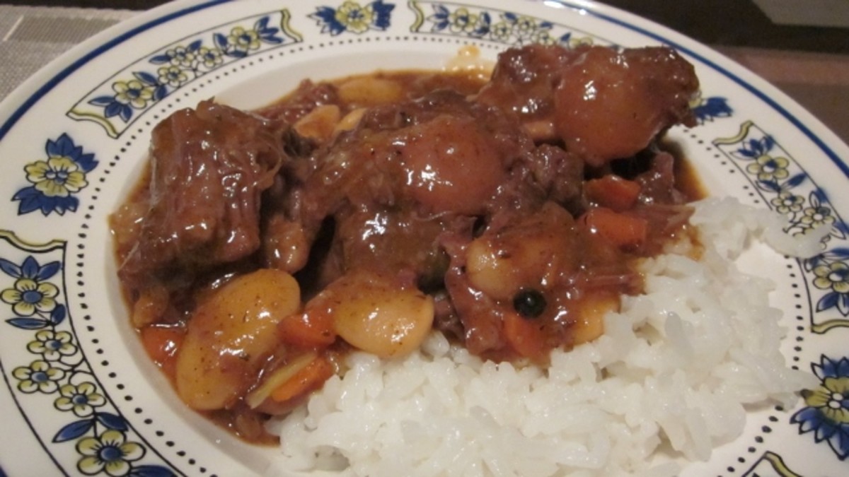 Oxtail stew with carrots, onions, and butter beans is best served over white rice.