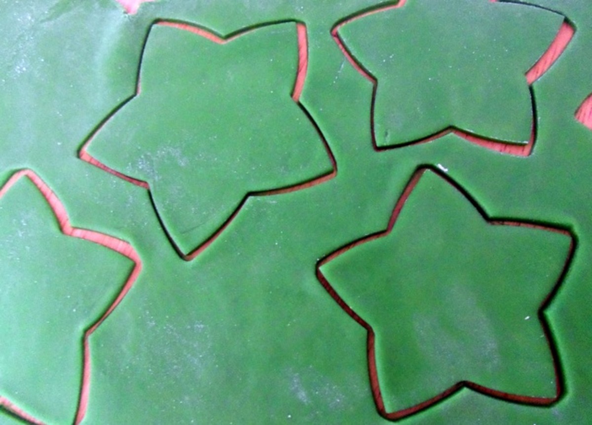 Roll the sugarpaste (fondant) out thinly and cut out the star shapes using the same cutters used for the cookies.