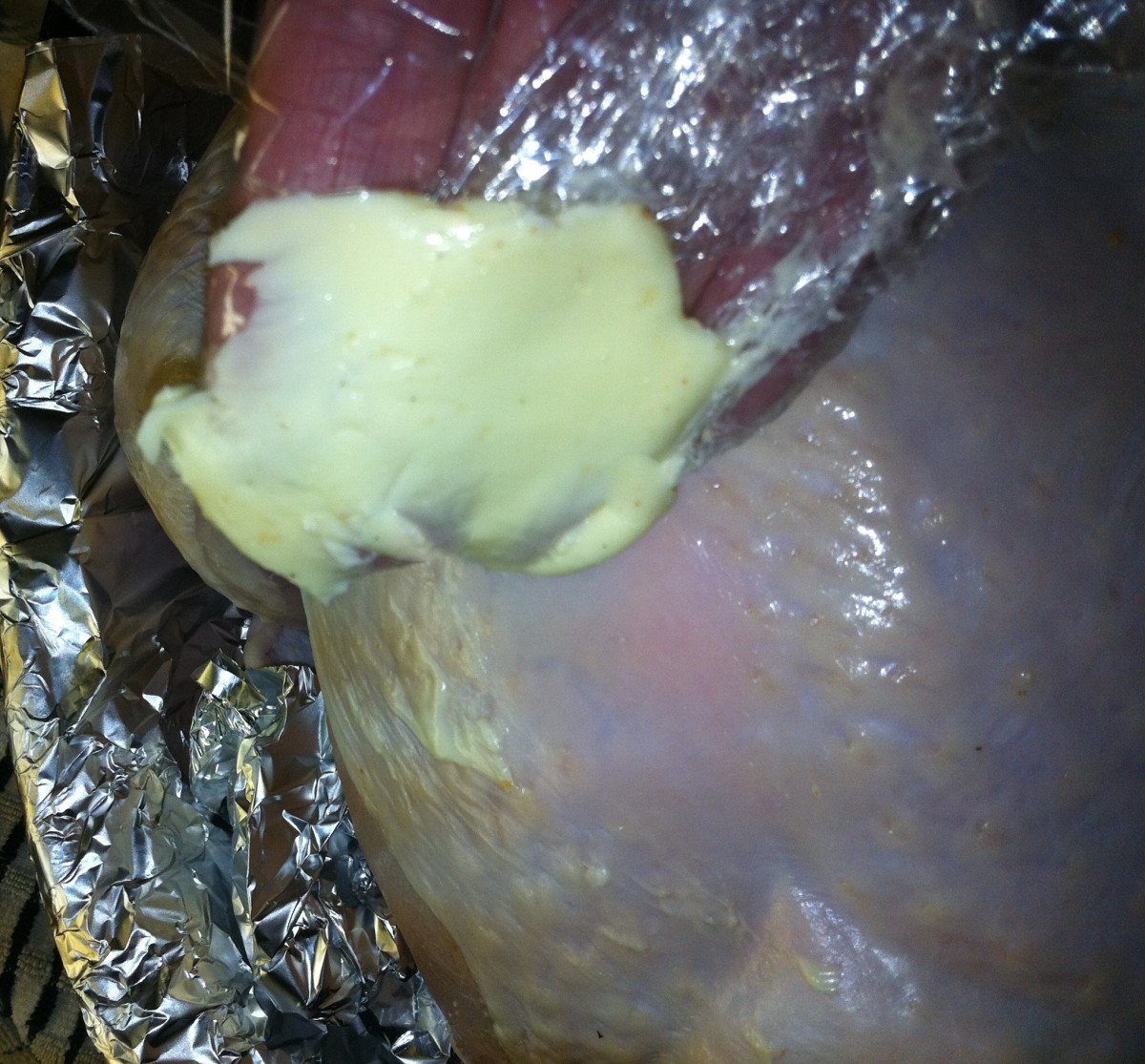 Applying butter to the turkey. I scooped the butter with plastic wrap in order to apply it to the bird.
