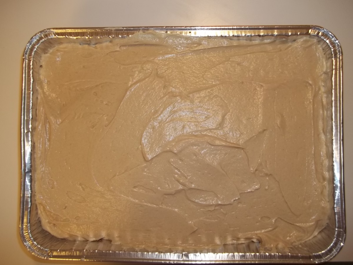 Cooled cake covered with creamy peanut butter filling and ready to be cooled some more.
