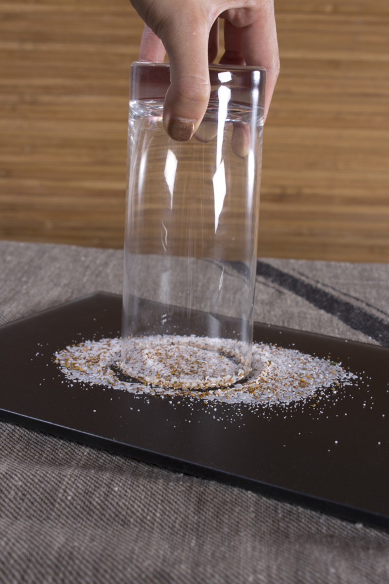 Spread the sugar/salt on a plate or flat surface.  Dip the moistened glass in.