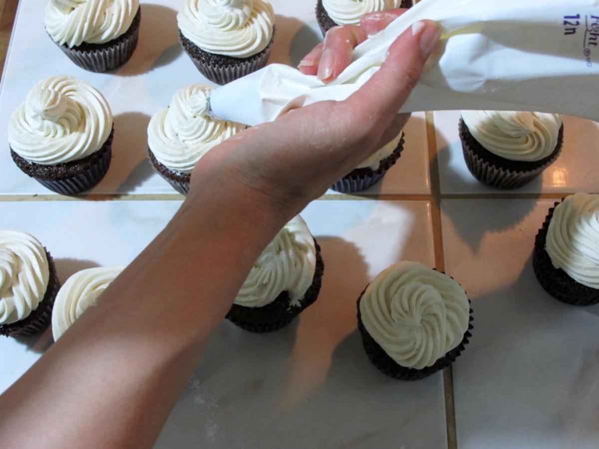 Piping frosting onto cupcakes