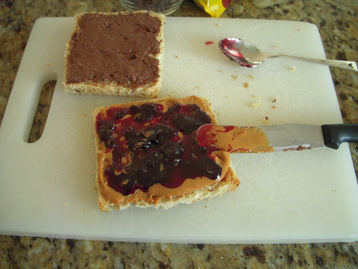 Dollop jam on top of peanut butter and spread it to edges of bread.