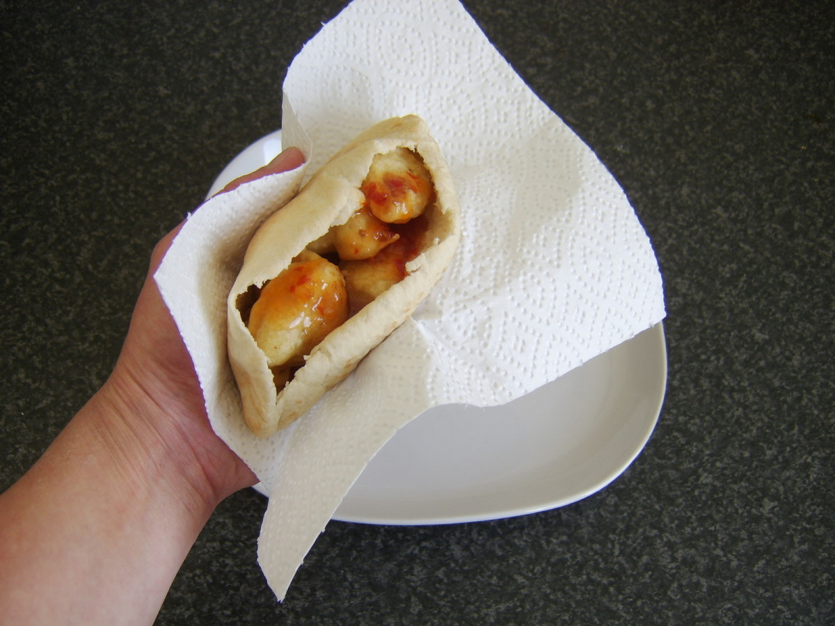 Battered chicken and pineapple pieces are stuffed in to a pitta bread pocket and drizzled with sweet chilli sauce