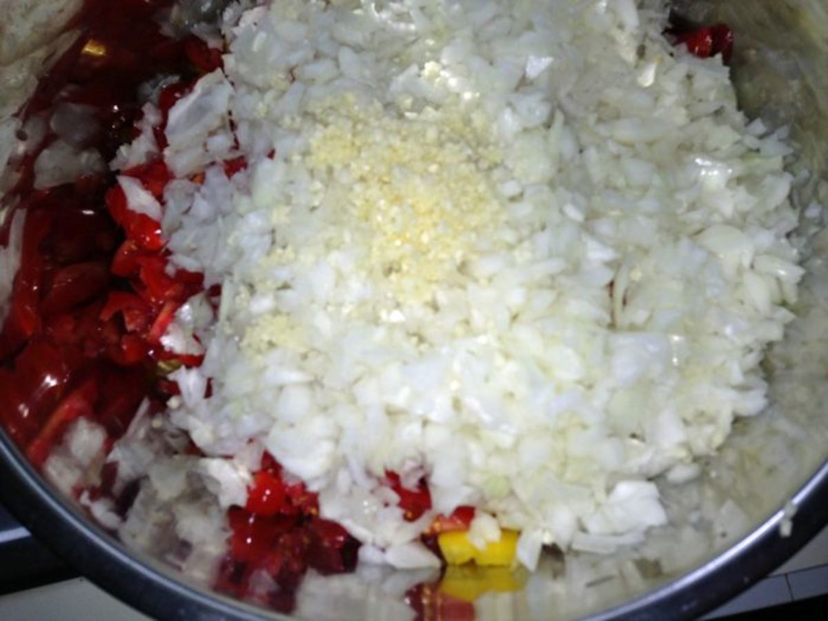 Chopped onions and minced garlic added to chopped veggies and tomatoes
