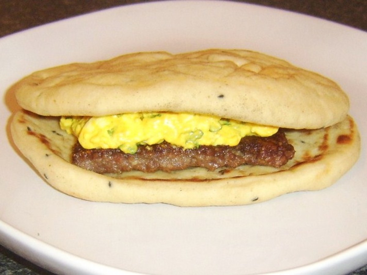 A curried Lorne sausage is topped with turmeric spiced egg in a naan bread sandwich