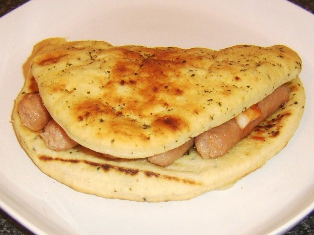 Pork sausage and Indian spiced onions are served in a naan bread sandwich