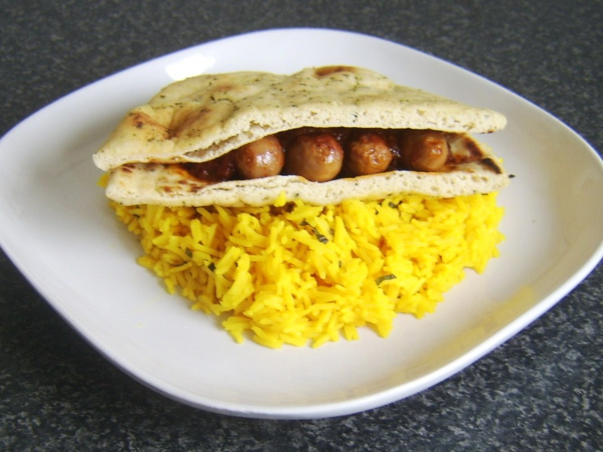 Beef sausages in a rich bhuna sauce served on a naan bread sandwich with rice