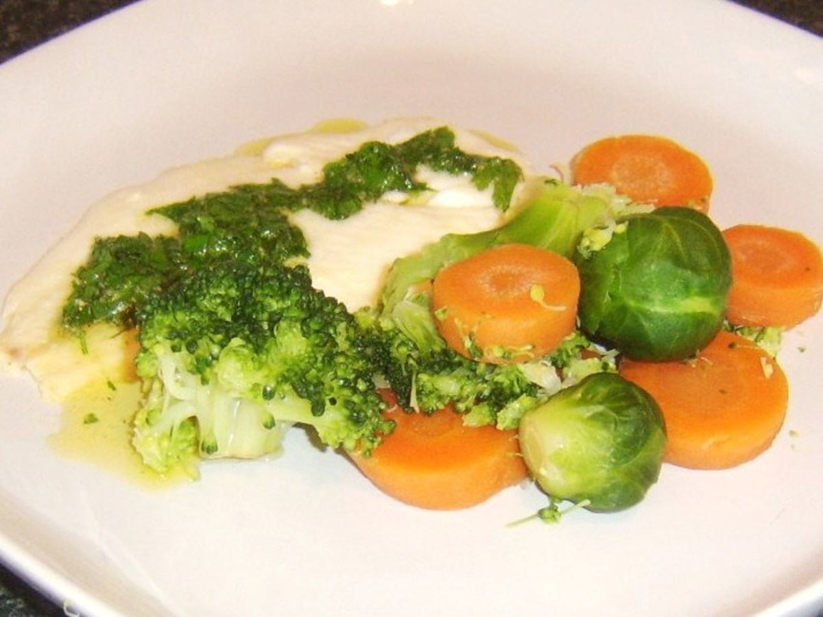 Plaice fillet is drizzled with parsley butter and served with assorted vegetables
