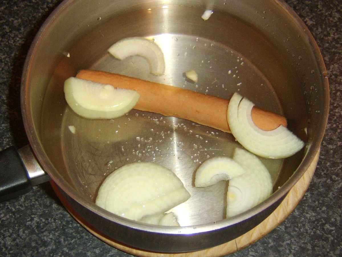 Hot dog and onion slices are added to some salted cold water