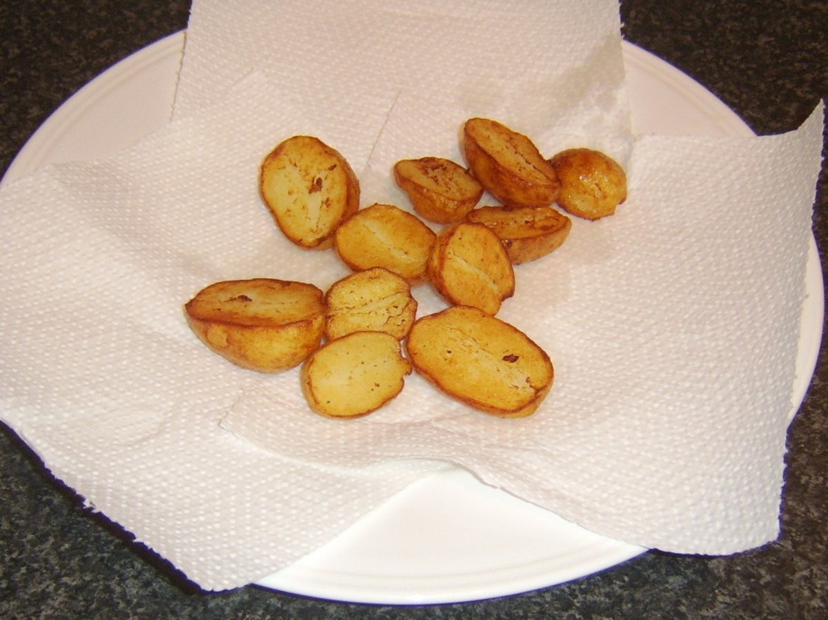 Pan roasted potatoes are drained on kitchen paper