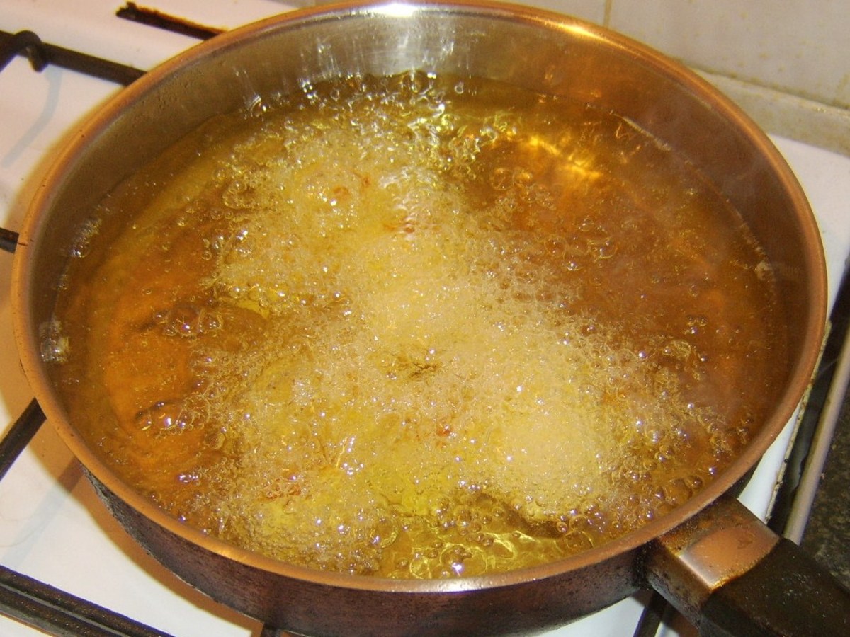 Peeled, cooked and cooled potatoes are deep fried in hot oil