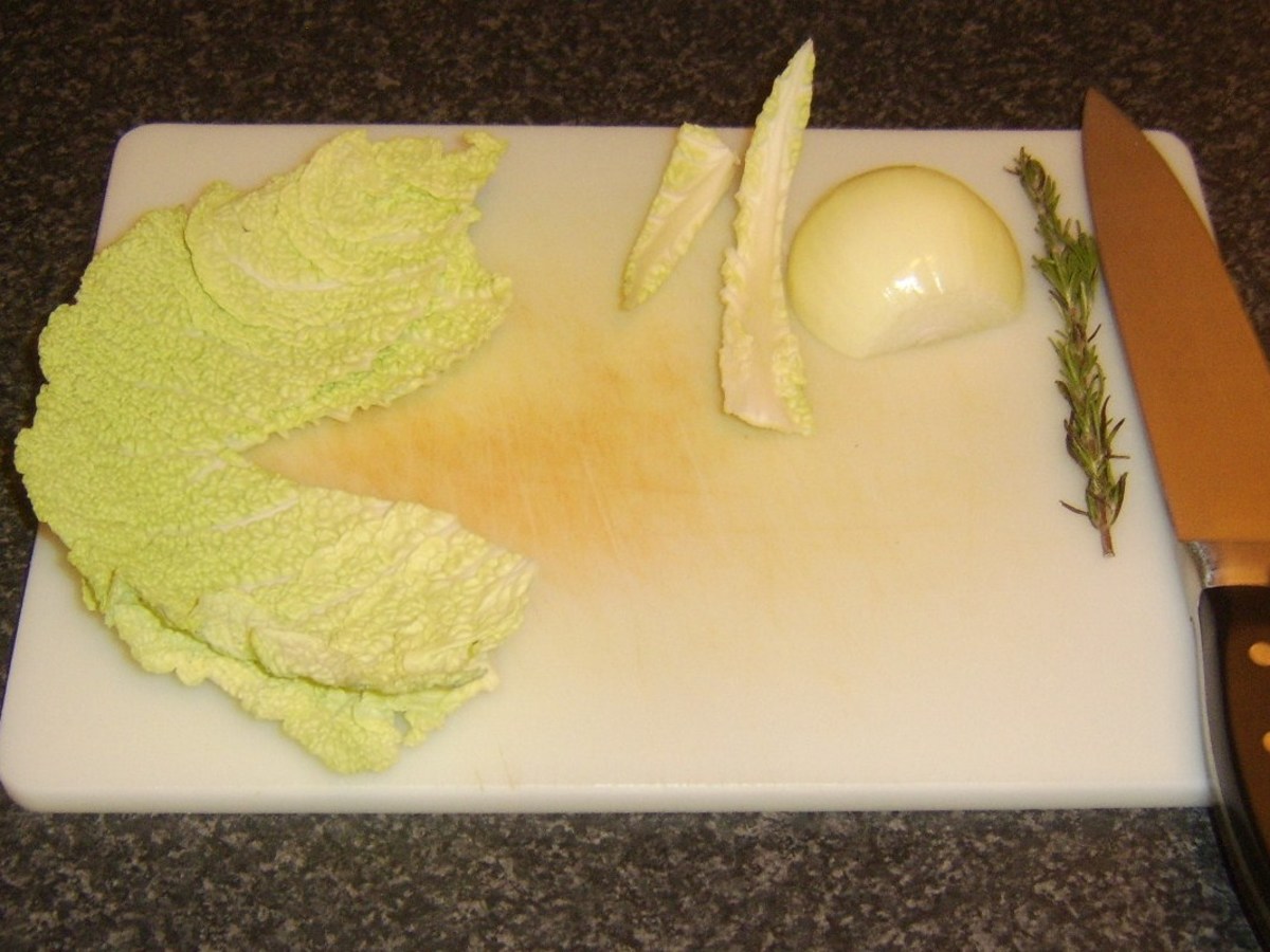 Tough central stalk is cut from Savoy cabbage leaves