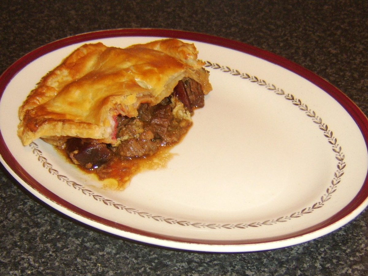 Pastry is plated on top of steak, beetroot and Stilton pie filling