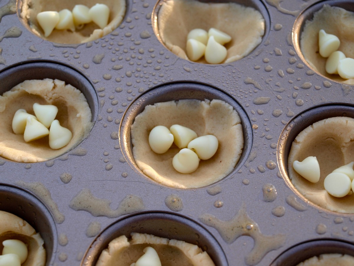 Add 4 white chocolate chips to each cookie cup.