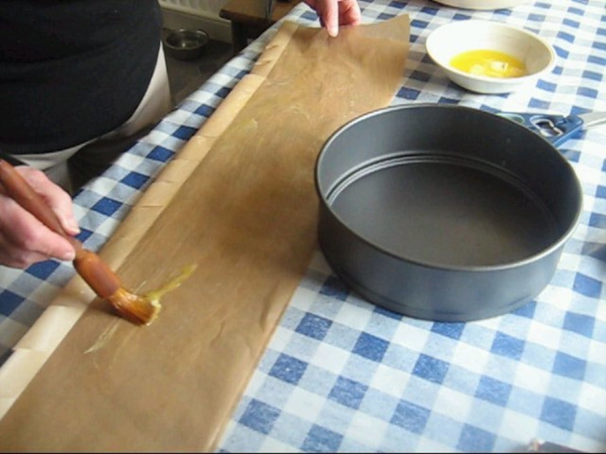 Brush the melted butter over the inside of the greaseproof paper.