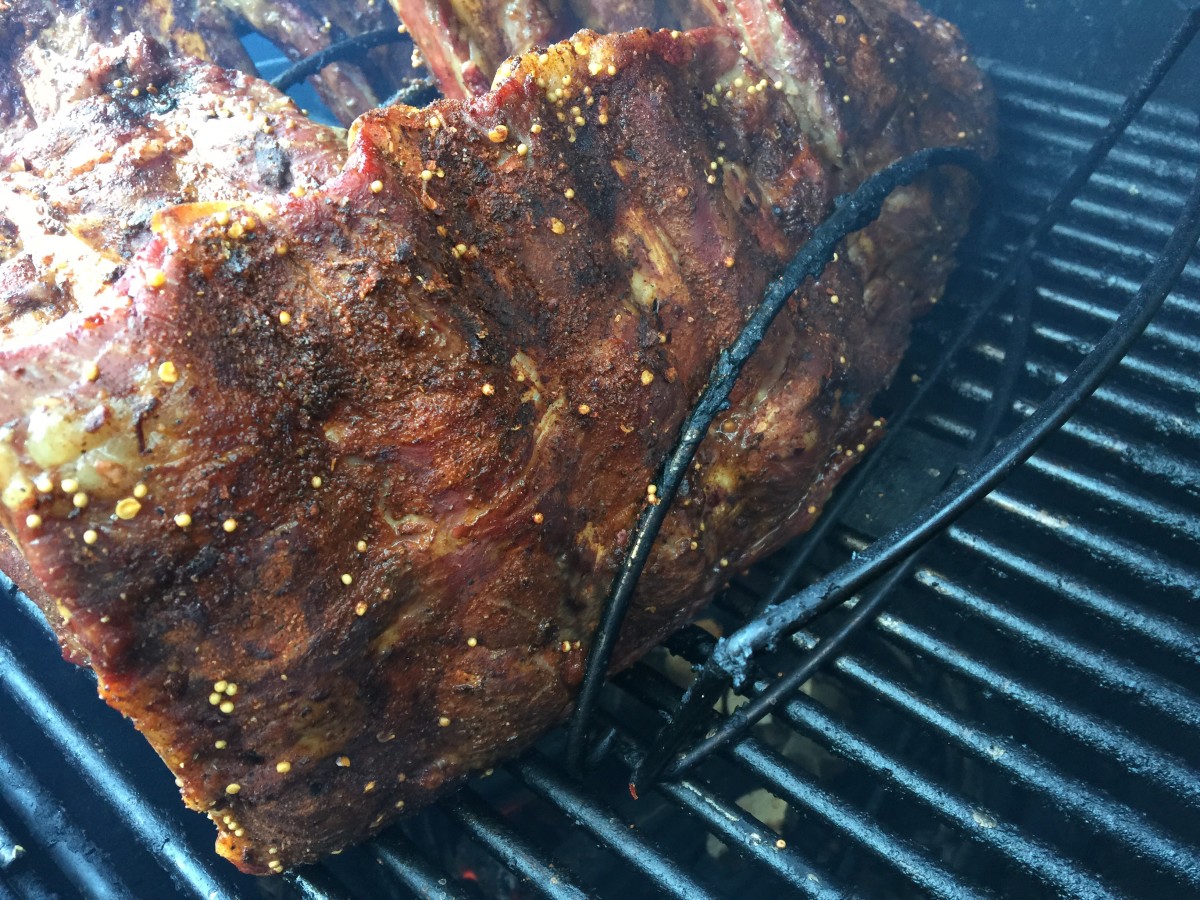 Beef ribs in rib rack on smoker.