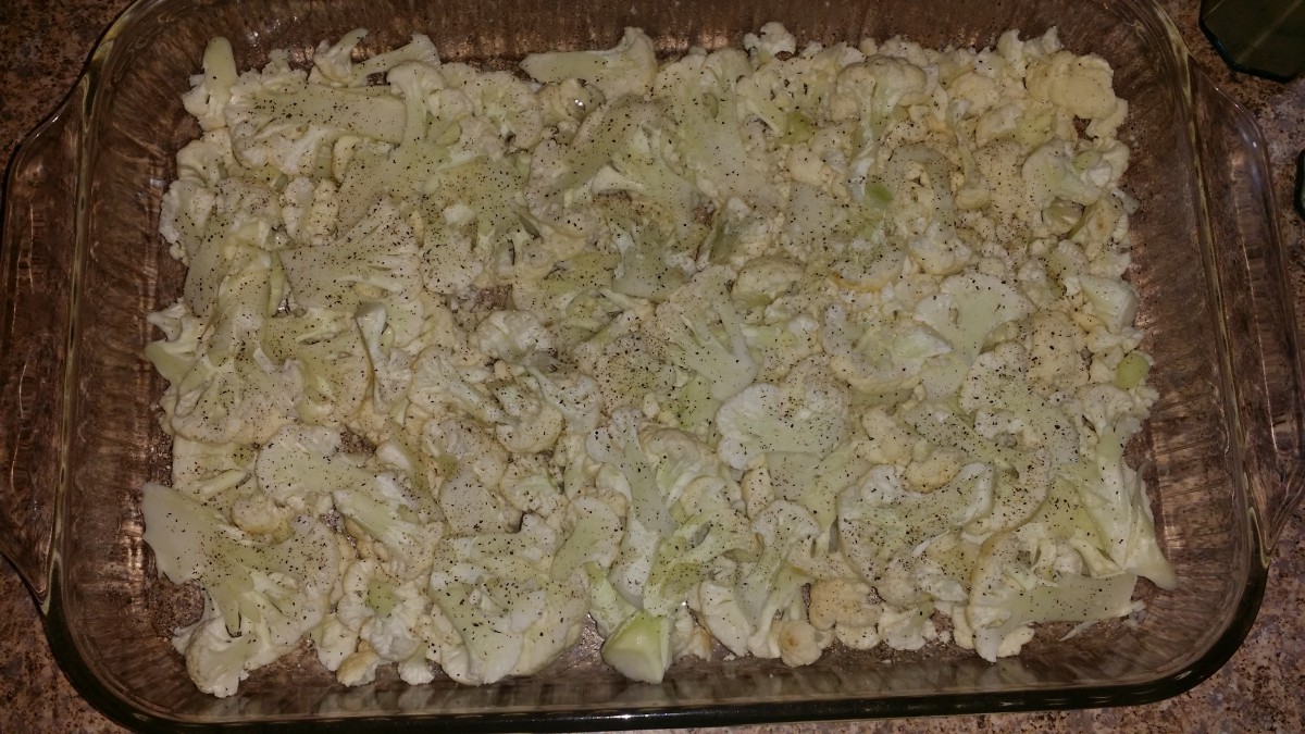 Layer the sliced cauliflower in the pan and sprinkle with salt and pepper.