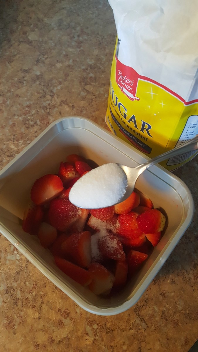 Sprinkle sugar over strawberries.
