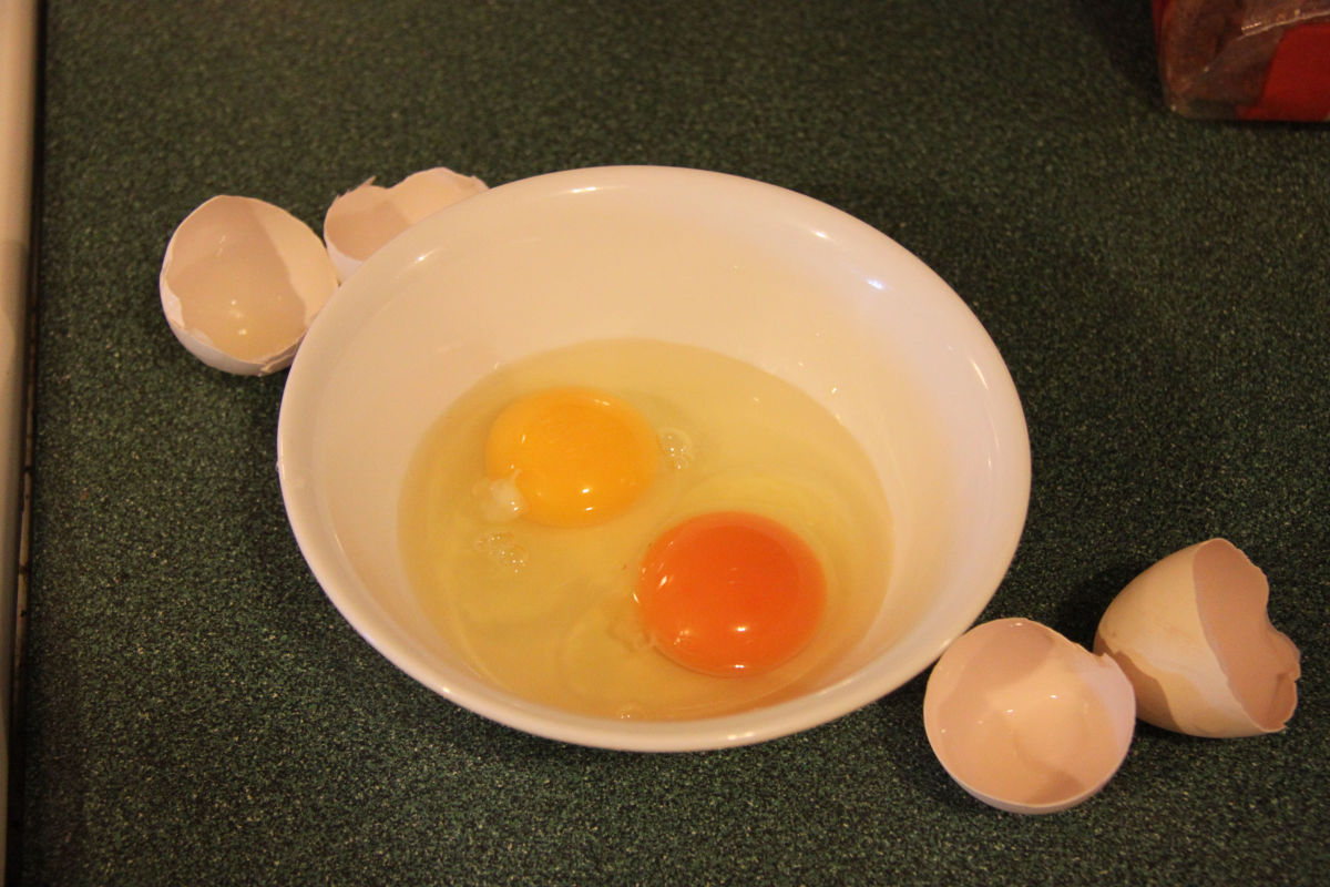 Two leghorn eggs, one from a battery-cage hen in a factory farm, and one from a hen who has been allowed to free range.