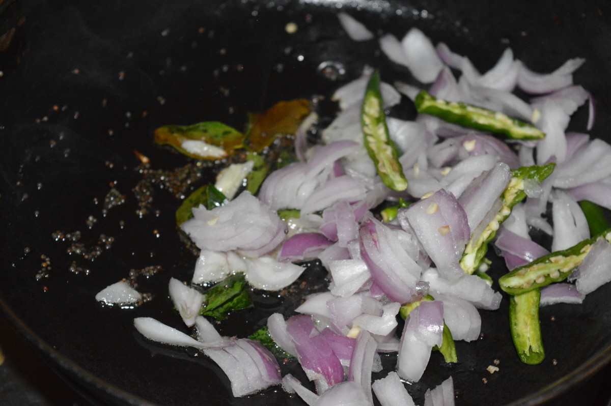 Step 4: Throw in the chopped onions and slit green chilies. Saute on low fire for 2 minutes.