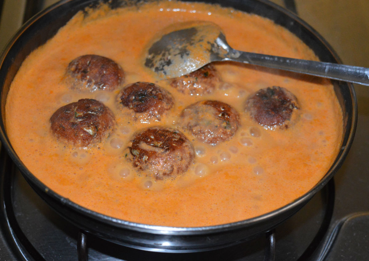 The koftas are immersed in the gravy before eating.