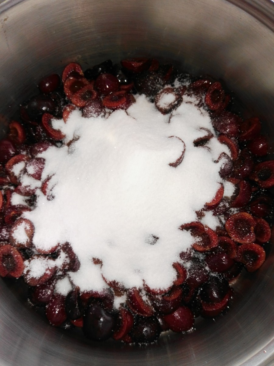 Add sugar to the freshly pitted cherries.