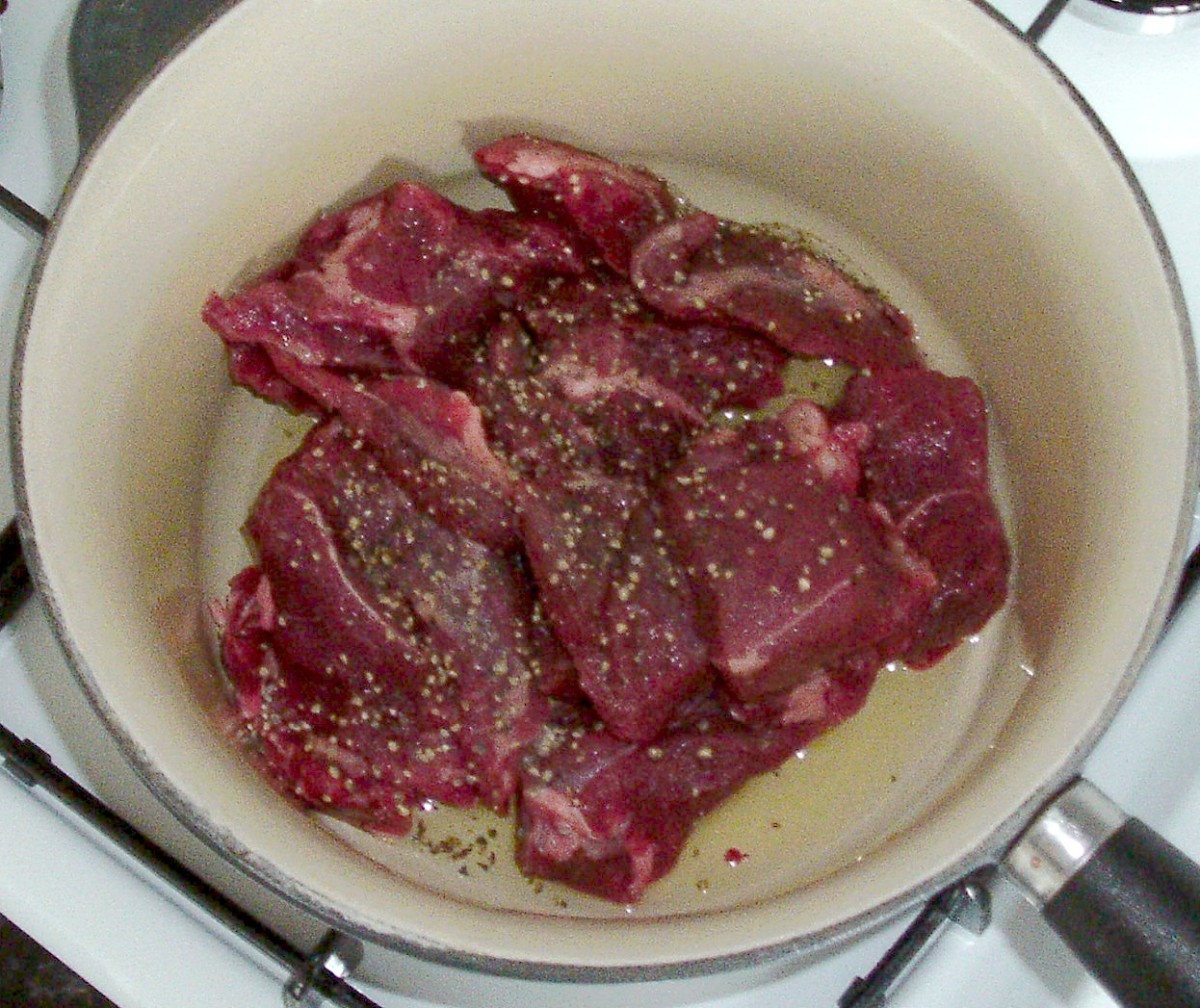 Alpaca meat is put in to a saucepan and seasoned with salt and black pepper