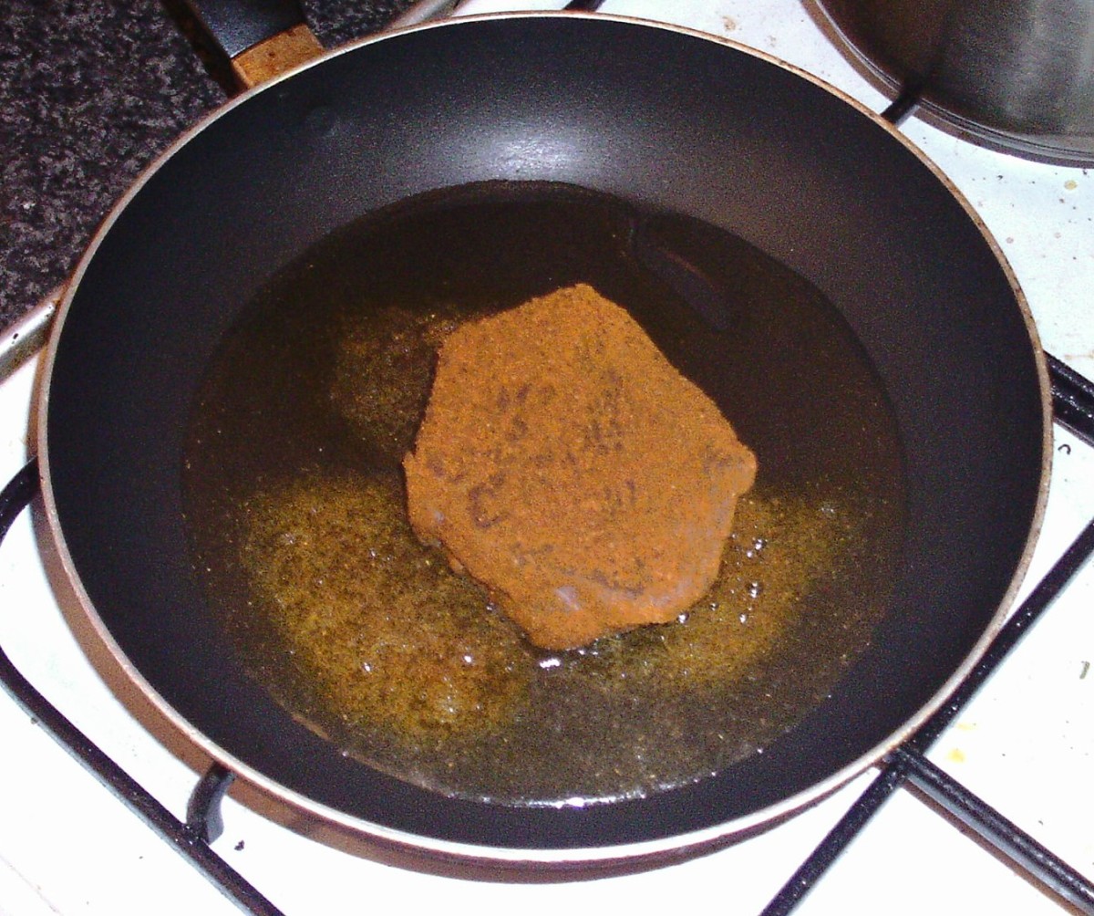 Ostrich steak is laid in hot frying pan.